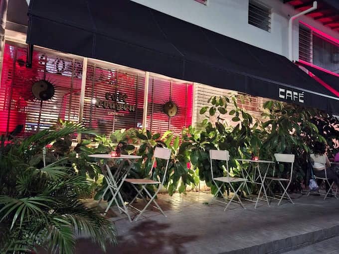 Disfruta de una terraza moderna y acogedora con decoración vibrante en un café urbano, ideal para eventos y reuniones en la ciudad. Elementos verdes y iluminación ambiental crean un ambiente perfecto en Eventario.