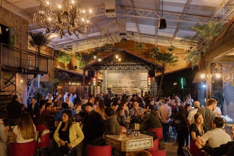 Eventario, evento en interior con decoración moderna y iluminación cálida, música en vivo en escenario, ambiente social y profesional, ideal para eventos corporativos y sociales en Colombia.