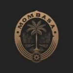 盾牌上有棕榈树、山脉和水的图案，代表 Moomba 品牌，风格简约优雅，适用于哥伦比亚的活动和活动服务。