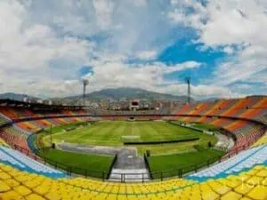 Sports stadium with colorful stands and well-maintained grass, ideal for sporting events and concerts in Colombia.