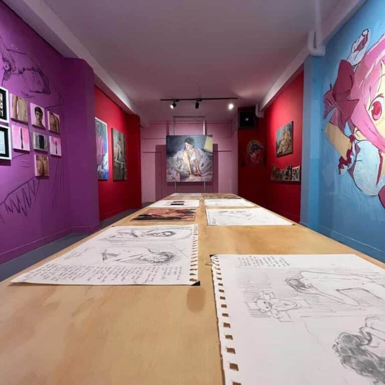 Bocetos y dibujos de arte en una exposición en la galería de arte, con paredes pintadas en colores vibrantes y obras y fotografías en exhibición, ideal para eventos culturales y creativos.