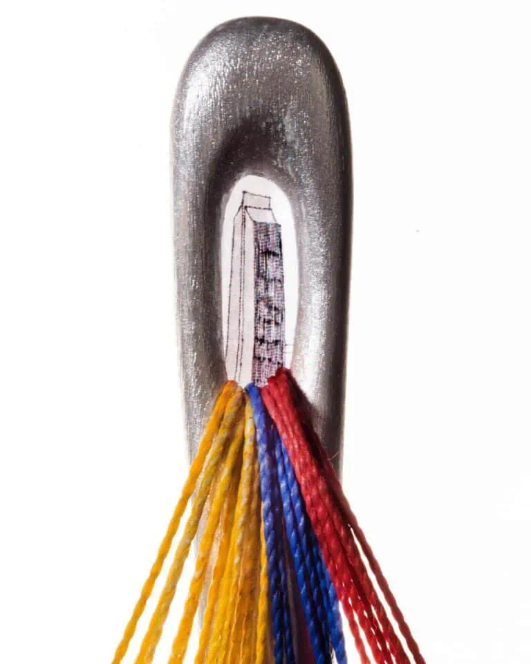 Faca com fios de cores variadas e um design artístico que combina elementos de arte e artesanato.