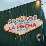 在兰格兰德的标志性场所 La Mecha 享受美好体验，这里氛围温馨，装饰灯光璀璨，还有照亮的欢迎标志，适合举办各种活动和社交聚会。