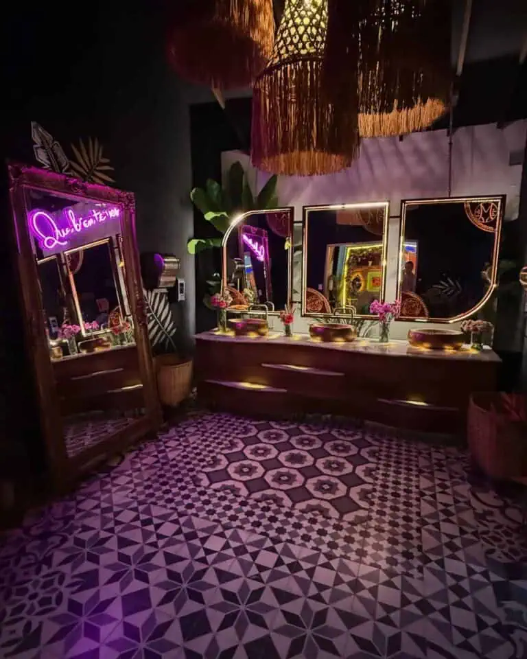 Elegante Badezimmerecke mit Spiegeln, Korblampen und Blumenvasen in einem dekorativen Event-Setting in einem modernen und anspruchsvollen Raum.