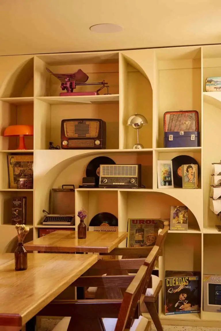 Retro-Unterhaltungsstation mit Nischen voller antiker Radios, Schallplatten und Vintage-Dekorationsartikeln für Veranstaltungen.