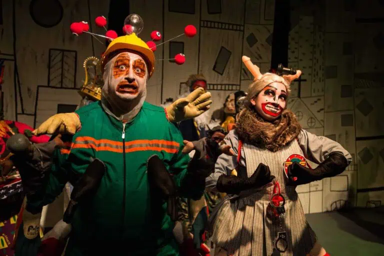 Des personnages de théâtre vivants avec des costumes extravagants et un maquillage saisissant se produisent lors d'un événement artistique, promouvant la créativité et le divertissement pour divers publics en Colombie.