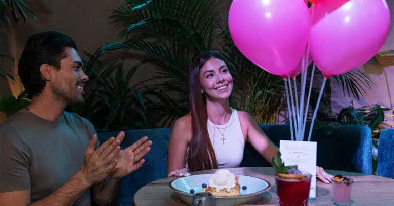 Birthday celebration at a restaurant with pink balloons, delicious food, and a festive atmosphere to celebrate special moments with friends and loved ones.