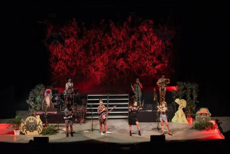 舞台上设有乐队，采用夜间主题装饰，配以红色灯光、装饰植物和人物元素，旨在推广文化艺术活动、创意和现场娱乐。