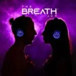 Casques éclairés par LED sur une paire de femmes, sur un fond néon violet, faisant la promotion de l'événement The Breath Act sur la méditation et le bien-être.