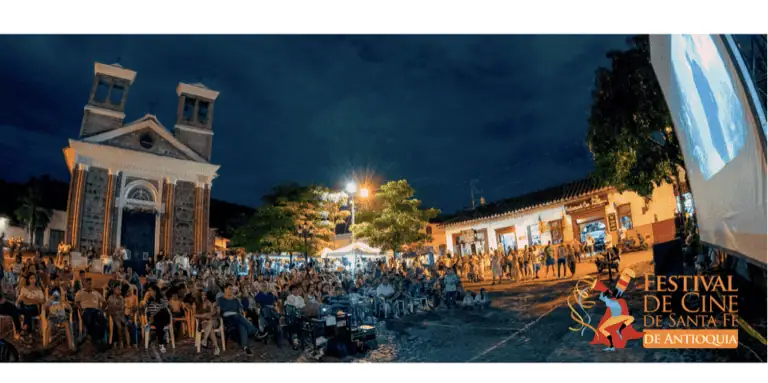 Public lors d'un festival de cinéma en plein air à Santa Fe, Antioquia, avec des spectateurs profitant d'une soirée culturelle et artistique lors d'un événement communautaire.
