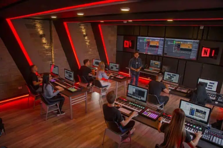 音乐制作工作室，学生们在现代化、技术先进的环境中，使用 Ableton Live、电脑和专业设备进行创作。