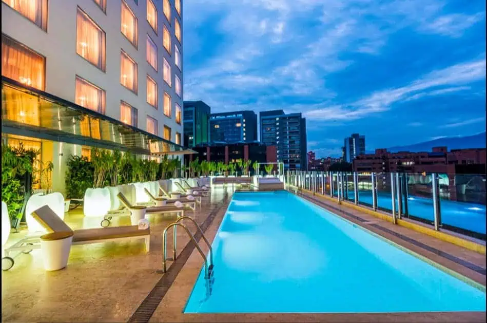 Ein Pool auf dem Dach eines Stadthotels bietet nachmittags Aussicht auf moderne Gebäude und ist ideal für Veranstaltungen und Tagungen im Freien.