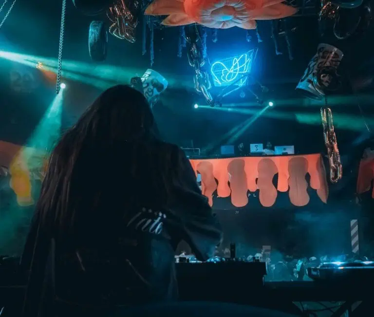 Entrer dans un événement musical avec un DJ dans une boîte de nuit éclairée au néon.