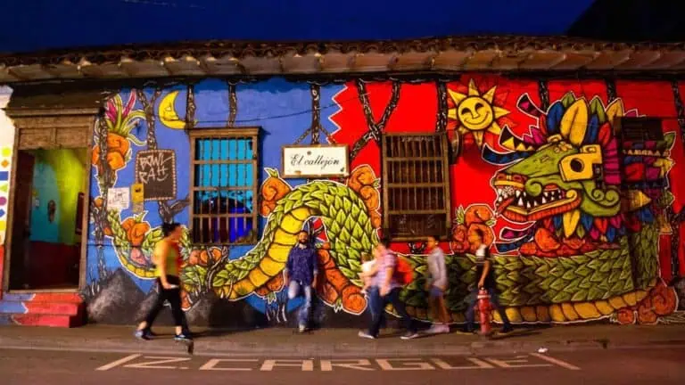 哥伦比亚麦德林一栋建筑外墙上的鲜艳壁画，展现了色彩缤纷的城市艺术和涂鸦。