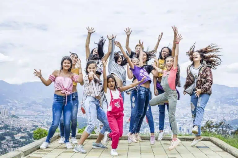 Jeunes filles profitant du plein air par une journée ensoleillée, célébrant et montrant leur joie en groupe, idéal pour les événements, les activités récréatives et les photos de groupe pour les promotions et le contenu lors d'événements et dans la communauté.