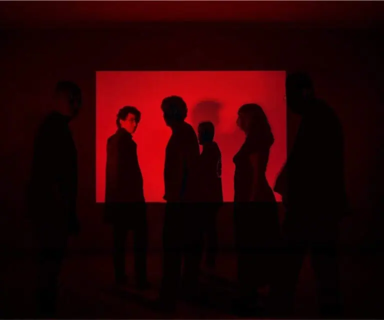 Public lors d'un événement d'art numérique, participants observant des œuvres d'art avec projection rouge, expérience immersive, exposition d'art contemporain, événement culturel et technologique en Colombie.