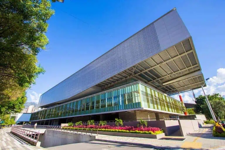 Modern evenementengebouw met innovatief design en ruime kantoren, in een stedelijke omgeving met groenvoorzieningen en een glazen gevel, ideaal voor conferenties en zakelijke bijeenkomsten.