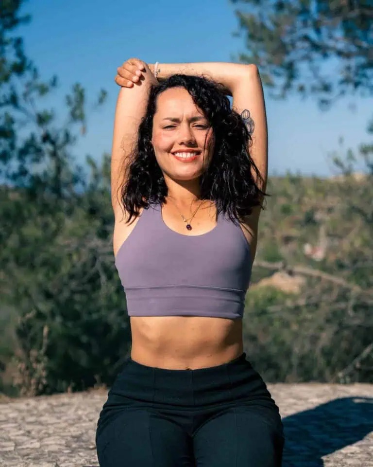 Une femme éclectique faisant de l'exercice en plein air par une journée ensoleillée, mettant en avant le bien-être et la santé dans des espaces naturels. Idéal pour promouvoir des événements et activités bien-être en Eventario.