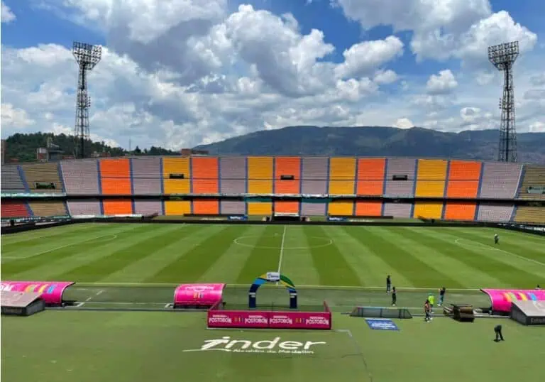 哥伦比亚，体育场内有足球场，看台色彩缤纷，天空阴云密布，这是一场体育赛事。