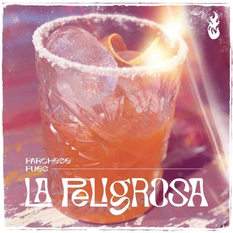 Cóctel de frutas tropical en vaso de cristal tallado, decorado con rodaja de naranja y hielo, ideal para eventos y celebraciones.