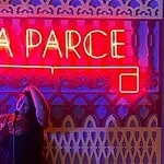 A woman on a stage with red neon signs, at an event in Bogotá, Colombia, under the theme of events and parties, promoting the organization and planning of events with Eventario.