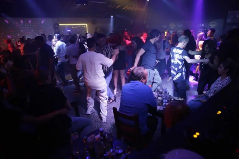 Junge Leute tanzen und amüsieren sich in einem Nachtclub mit Neonlichtern und ausgelassener Atmosphäre – ideal für Veranstaltungen und Partys in Bogotá.