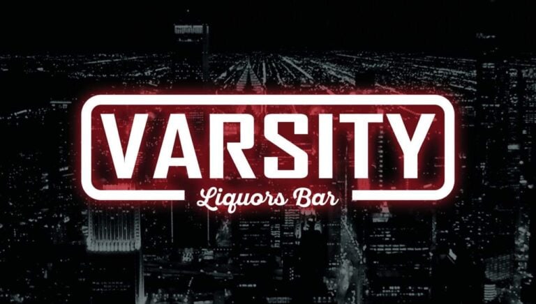 VARSITY Liquors Bar en ciudad nocturna con neón, ceremonia moderna, ambiente vibrante, espacio social y bebidas alcohólicas, experiencia urbana, punto de encuentro nightlife.