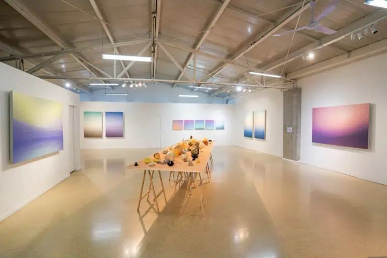 Arte, cultura e eventos em uma galeria de exposições com pinturas e esculturas abstratas, ambiente moderno com iluminação LED, espaço para eventos culturais e artísticos em Bogotá.