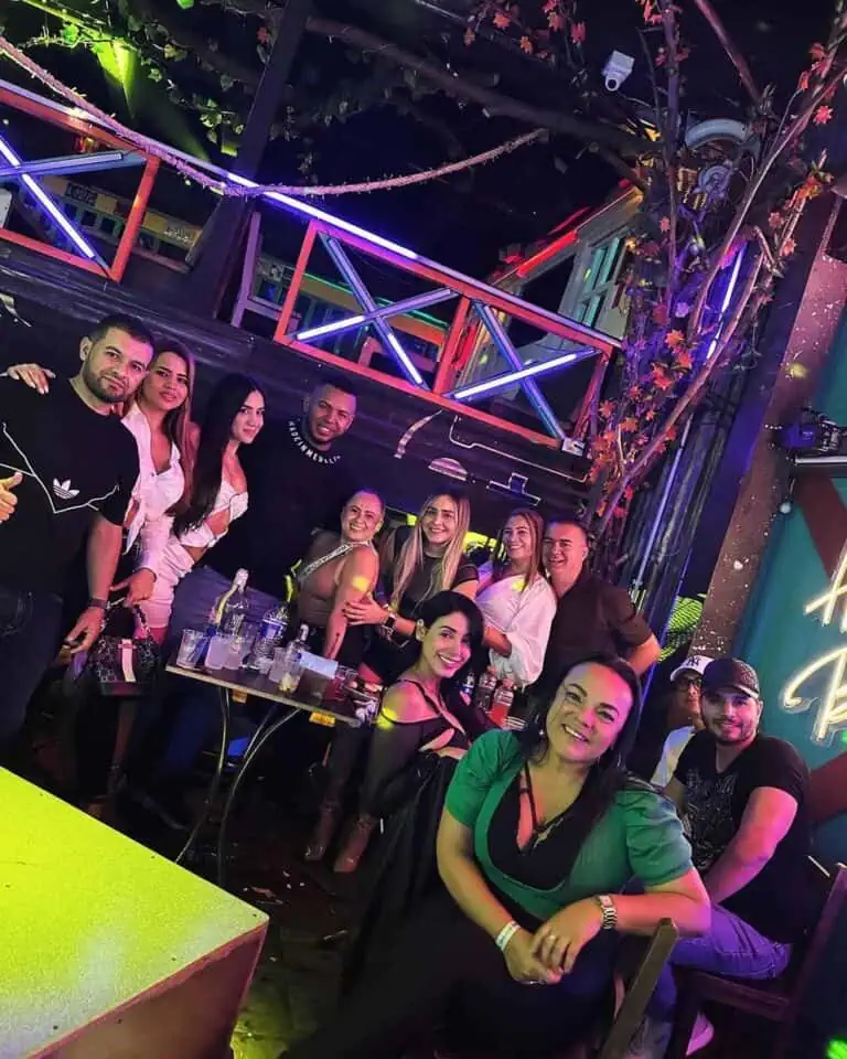 Amusement et ambiance lors d'un événement social avec un groupe de personnes souriantes et s'amusant dans un espace avec une décoration moderne et des néons vibrants lors d'un événement organisé par Eventario.