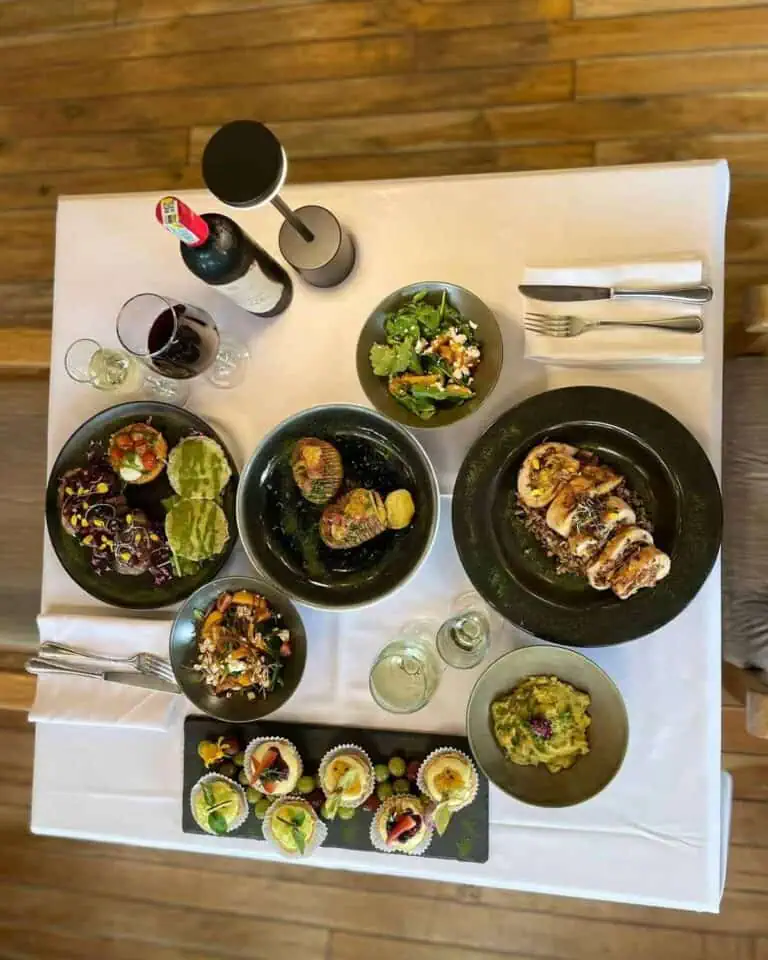 精致多样的菜肴，包括沙拉、肉类和美味甜点，摆放在装饰精美的餐桌上，是哥伦比亚庆祝活动和社交聚会的完美之选。