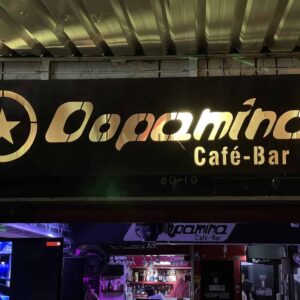 Logo de Eventario Café-Bar iluminado en la noche con ambiente urbano y moderno.