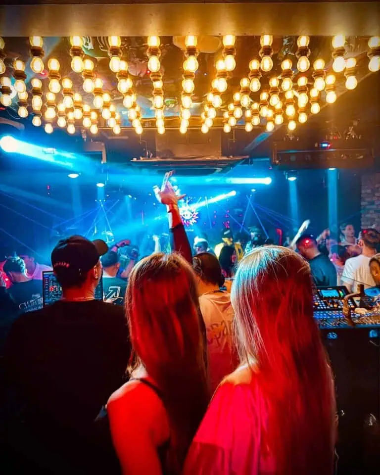 舞台灯光璀璨，观众们在灯光绚丽、气氛热烈的夜总会里欣赏着音乐表演。