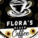 Taza de café negro con flores y texto "Florers Black Coffee" en estilo artístico y fondo oscuro. Ideal para promoción de cafeterías y eventos relacionados con el café.