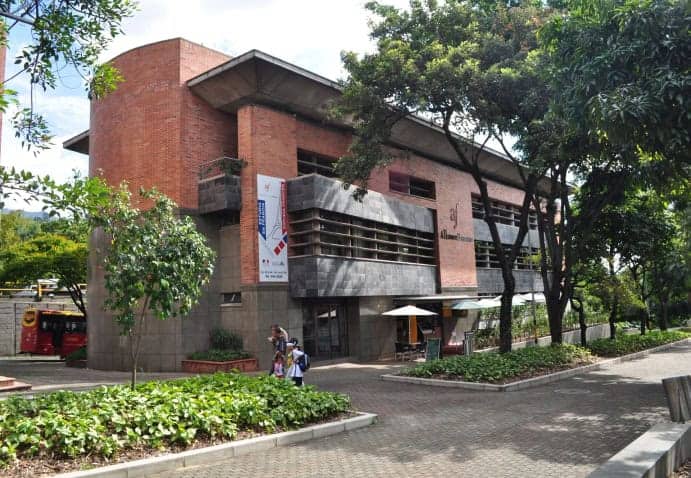 Edificio moderno de eventos en un entorno natural, ideal para conferencias y reuniones empresariales. Fachada de ladrillo y concreto, rodeada de árboles y espacios verdes en la ciudad de Bogotá.