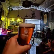 在一家氛围活跃的现代酒吧里，顾客们正在享用精酿啤酒，这家酒吧叫做…… Eventario 在哥伦比亚。