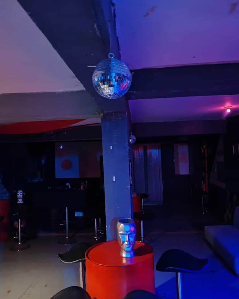 Esquina de evento con decoración moderna y luminosa, cuenta con disco bolas y muebles de estilo contemporáneo, ideal para eventos y experiencias memorables en Colombia.