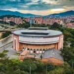 La cathédrale de Bogotá, dans un cadre urbain avec des montagnes en arrière-plan, entourée d'arbres et de bâtiments modernes, offre un espace pour des événements et des réunions dans la ville.