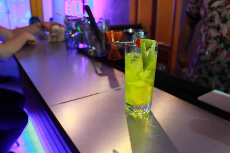 Refresco verde en bar con iluminación de neón viva, cócteles y ambiente de fiesta, ideal para eventos y celebraciones en Cartagena.