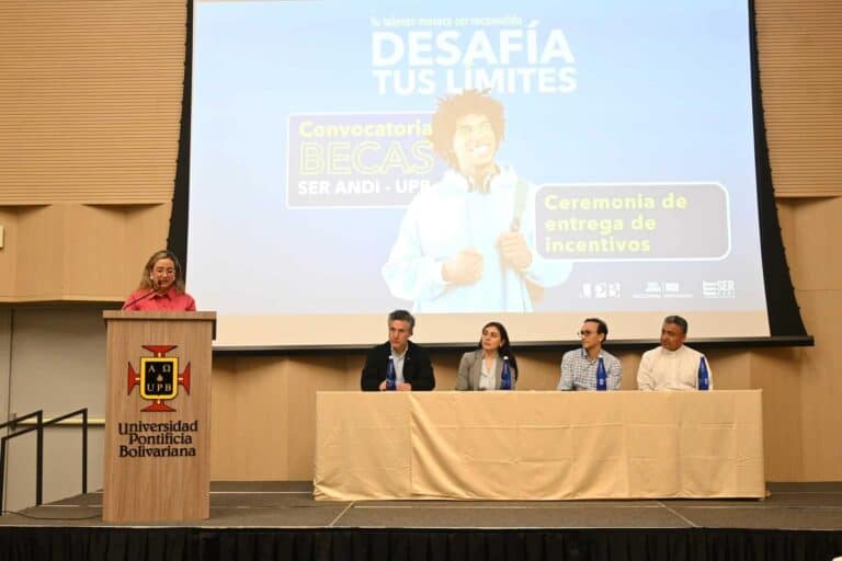 Talento universitario en evento de entrega de becas y incentivos en la Universidad Pontificia Bolivariana, con panel de expertos y presentación sobre oportunidades académicas y becas en la educación superior.