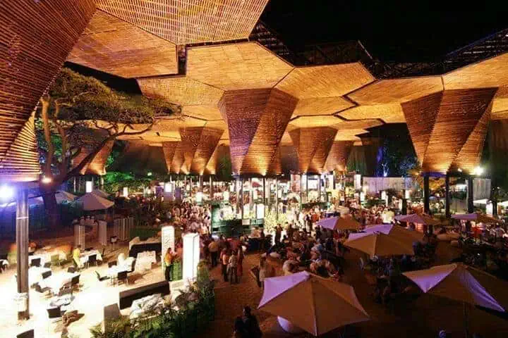 Un espace événementiel extérieur spacieux avec une conception architecturale innovante, un éclairage ambiant et des coins salons, idéal pour les célébrations, les salons professionnels et les rassemblements sociaux dans un cadre moderne et sophistiqué.