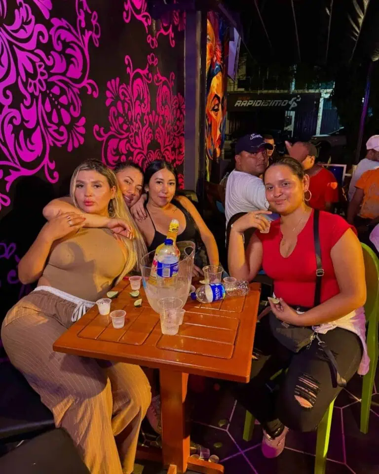在一家氛围活跃、装饰色彩缤纷、饮品丰富的餐厅里，与朋友们一起参加社交活动，享受美好的夜晚，展现哥伦比亚的活动和社交聚会体验。