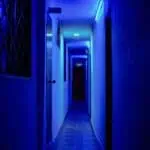 Tür im Flur mit blauer Neonbeleuchtung, ideal für Veranstaltungen und Themenräume.