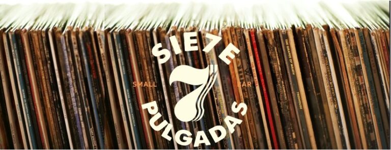 Discos de vinilo con logo de SiETE PULGADAS, colección musical vintage, fondo de vinilos, tienda de música, eventos culturales, colección de discos, eventos musicales, venta de vinilos, cultura musical.