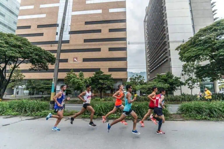 Runners participating in an urban marathon in a modern city, an outdoor running sporting event, athletes in motion during a street race.