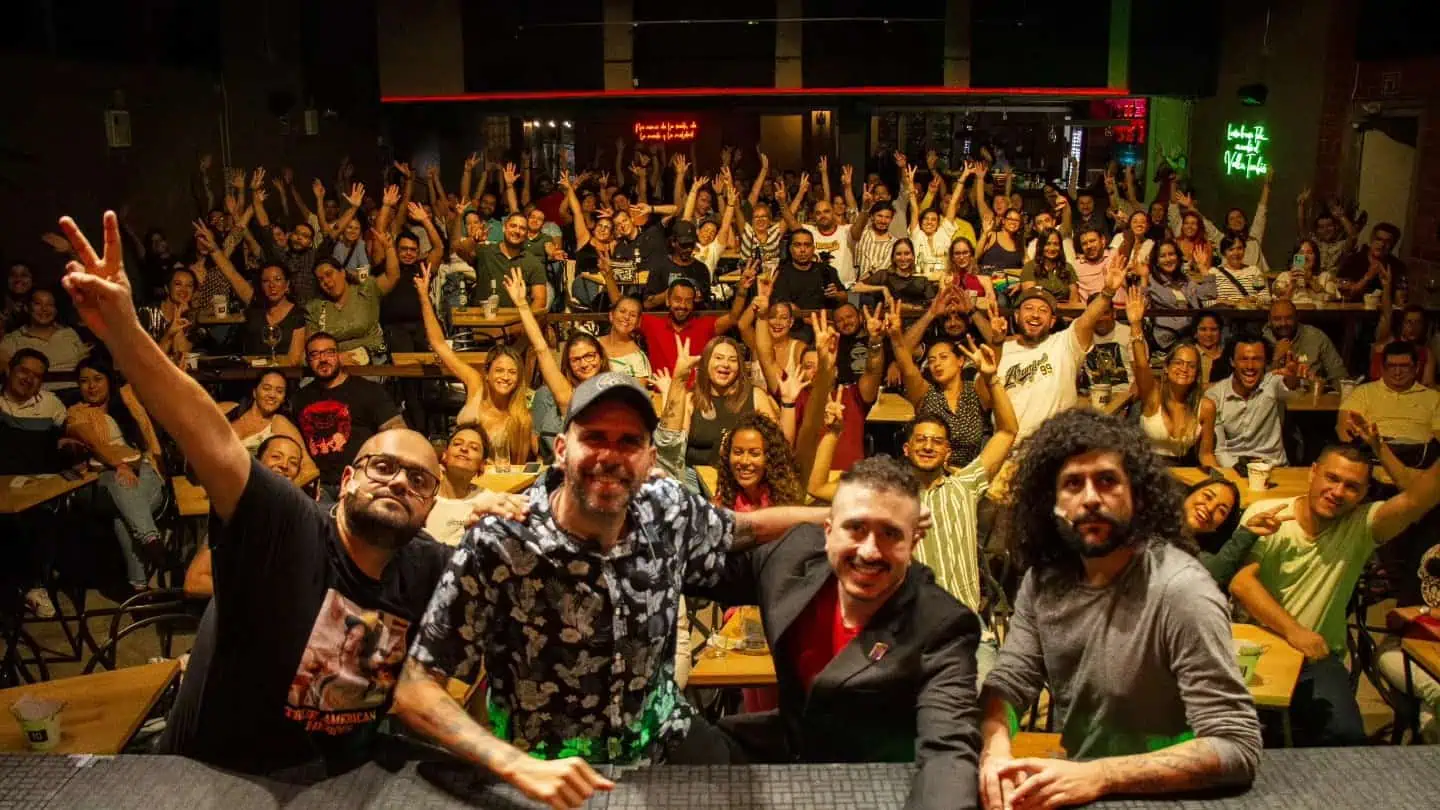 Des personnes lors d'un événement dans une atmosphère divertissante et de réseautage dans un espace éclairé de couleurs vives, avec des participants qui s'amusent et sourient lors d'un événement social et professionnel en Colombie.