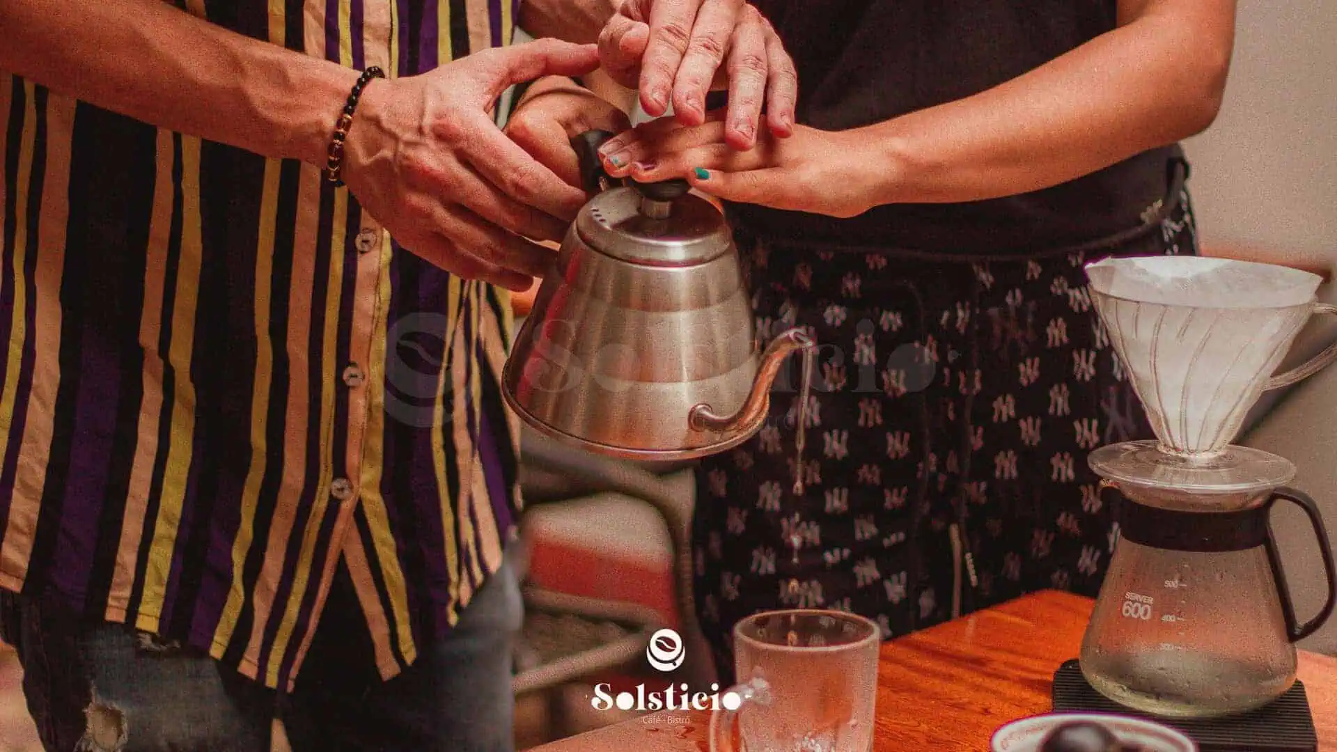 Baristi che preparano il caffè filtrato in una moderna caffetteria, mettendo in risalto l'arte del caffè e l'esperienza degli eventi gastronomici.