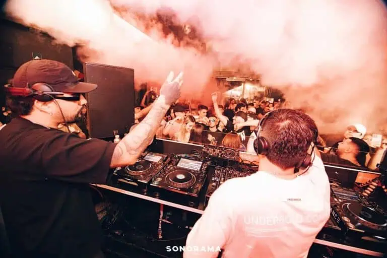 Dance floor with live DJ at an electronic music event with vibrant atmosphere and smoke effects, perfect for themed events and live music parties.