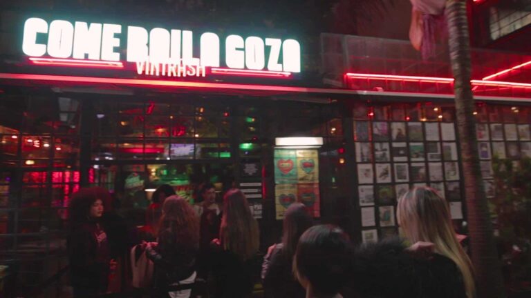 Beso de entrada al restaurante Come Here Coz en Vilarrasi, ambiente nocturno con luces de neón en un espacio moderno y acogedor para disfrutar de buena comida y reunión social.