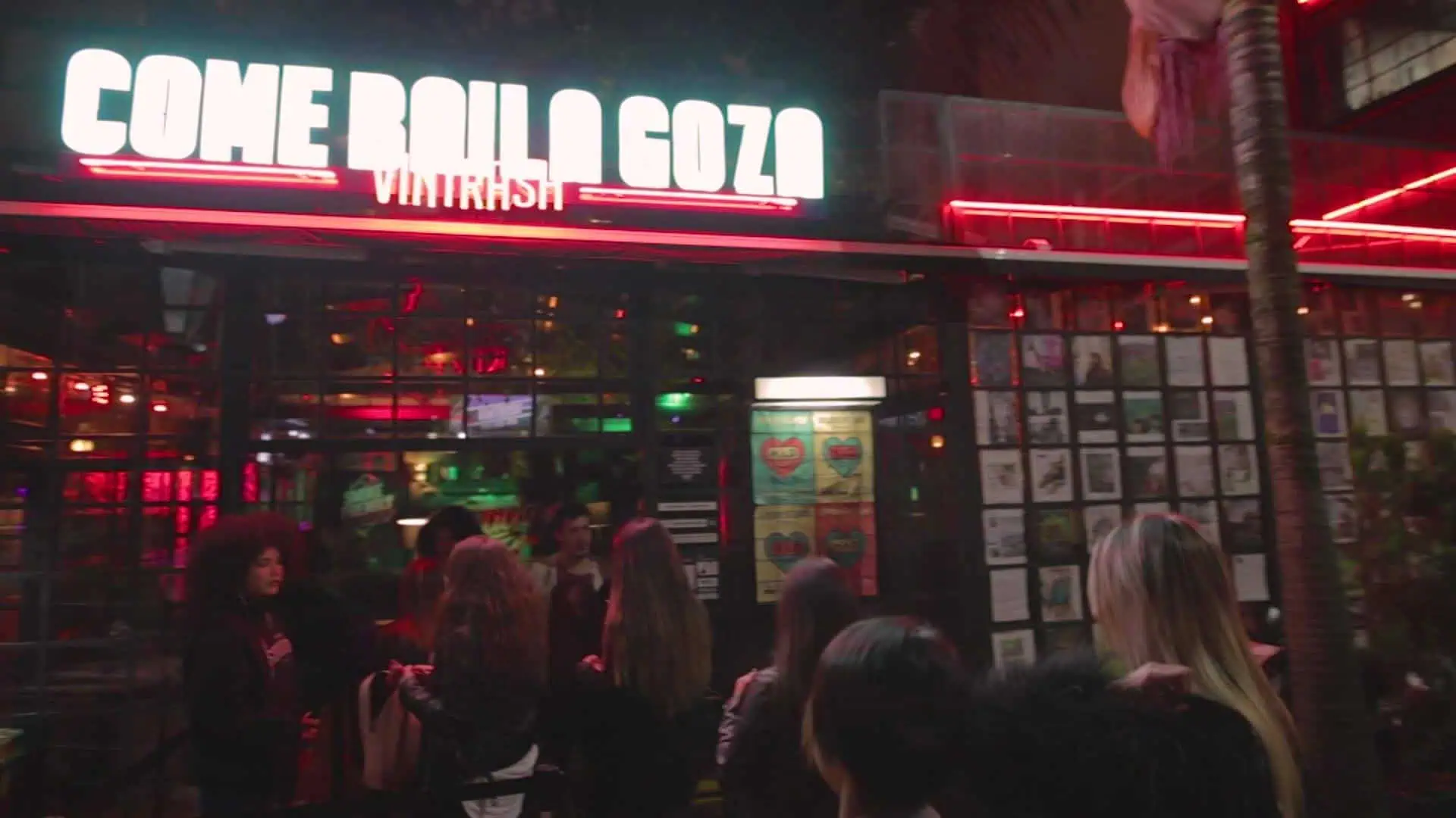 Baiser à l'entrée du restaurant Come Here Coz à Vilarrasi, une ambiance nocturne avec des néons dans un espace moderne et accueillant pour déguster de la bonne nourriture et socialiser.