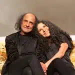 Je vois un couple aux cheveux bouclés posant sur une scène, événement, photographie de portrait, portrait de couple, célébration, amitié, joie, vie sociale, amitié et bonheur, événement, dans l'espace, capacité sociale, événement social, rassemblement social, événement de la vie sociale, événement de célébration, événement d'amitié et de bonheur, personnages sociaux.